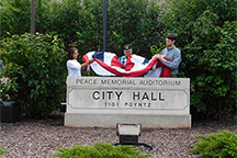 Mayor Usha Reddi, Jim Sharp and County Commission Chair Ben Wilson put finishing touch on new signage.